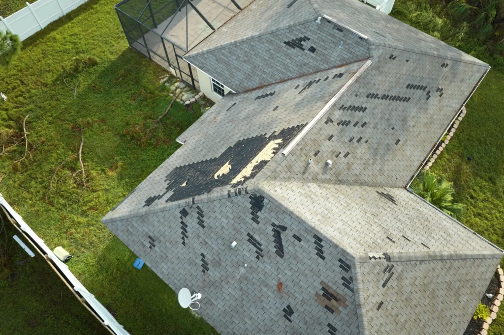 Suffolk County home with missing asphalt shingles after a severe storm