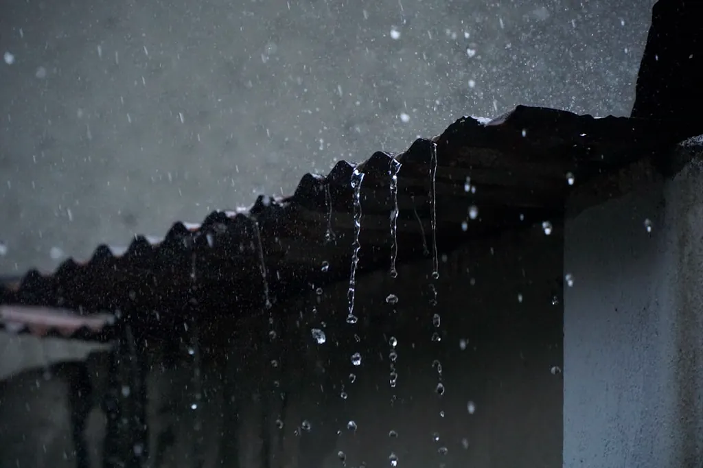 Rain pouring off the edge of a roof during a Suffolk County storm