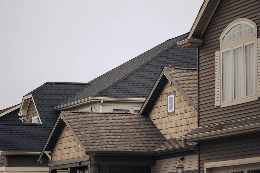 Well-maintained asphalt shingle rooflines and dormers on a residential home